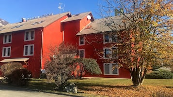 Un edificio rojo con múltiples ventanas y techo de tejas.