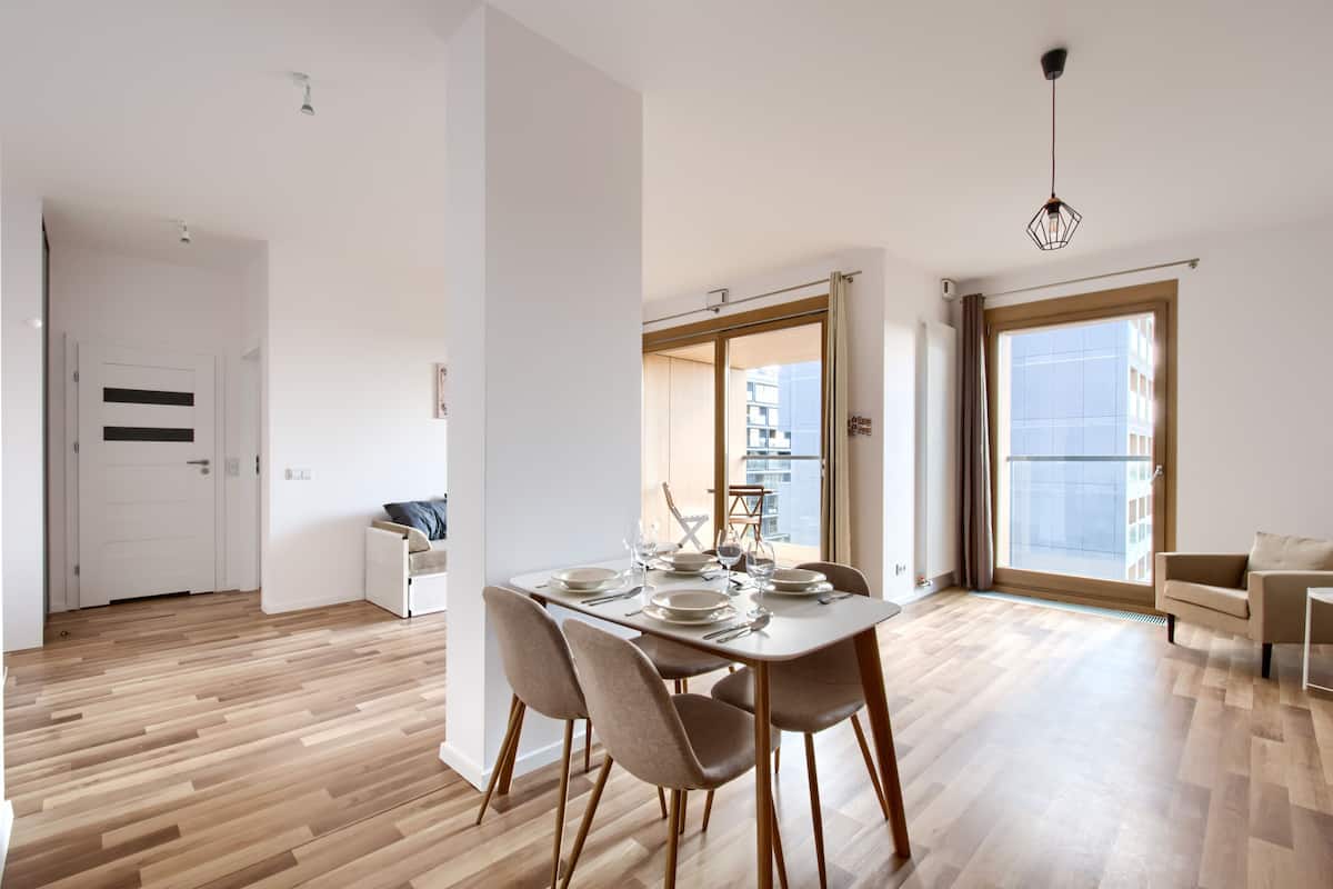 Un appartement moderne comprenant un coin repas, un canapé et une grande fenêtre.