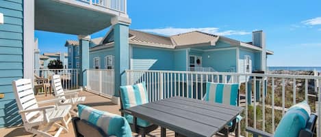 Propiedad frente a la playa con un patio cubierto que incluye mobiliario exterior y una mesa.