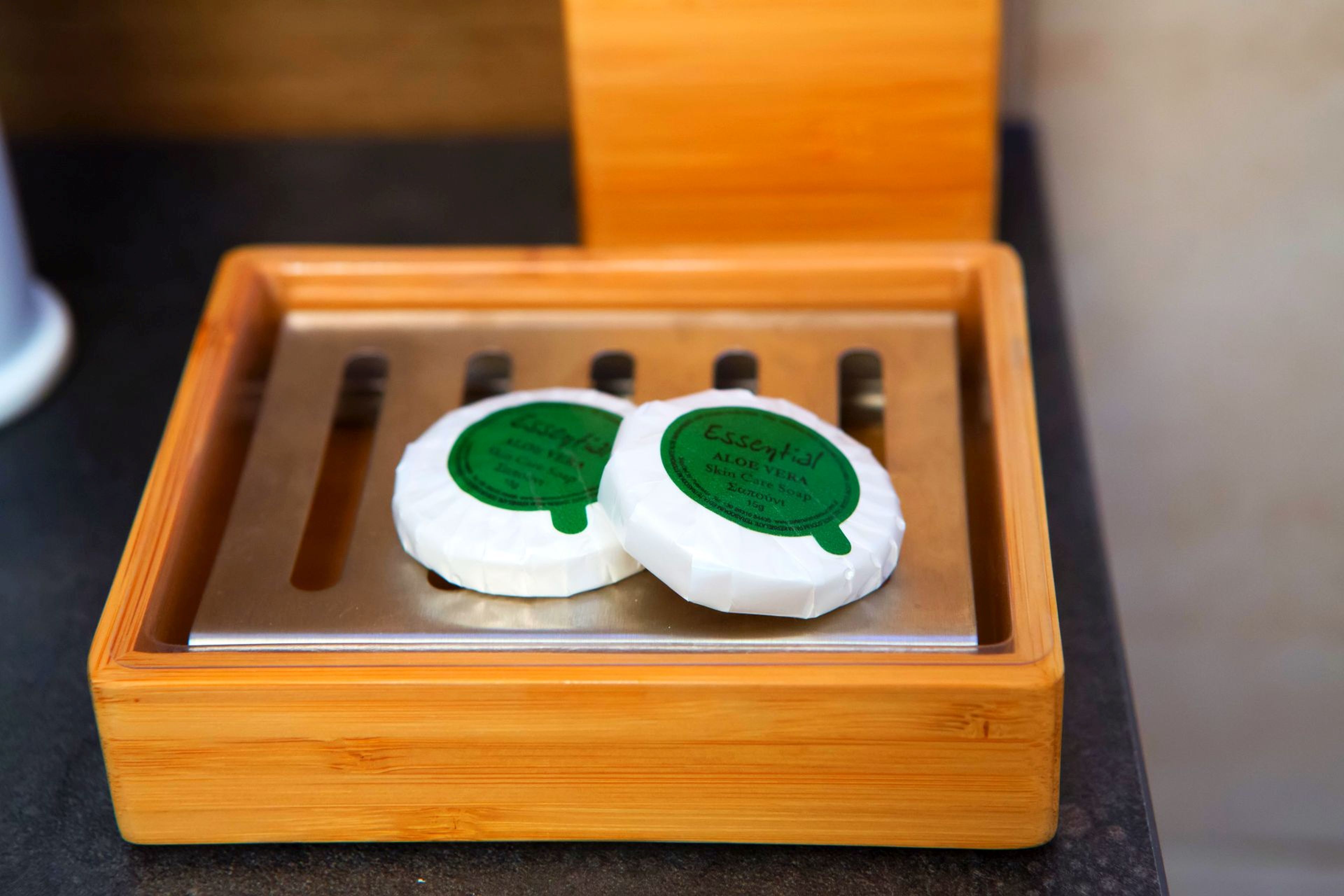 Two white bars of soap with green labels in a wooden box.