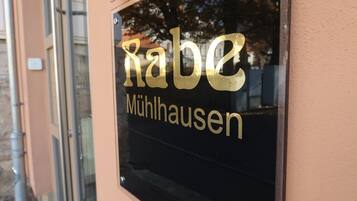 Une enseigne portant le nom « Rabe Mühlausen », en lettres dorées sur un fond noir.