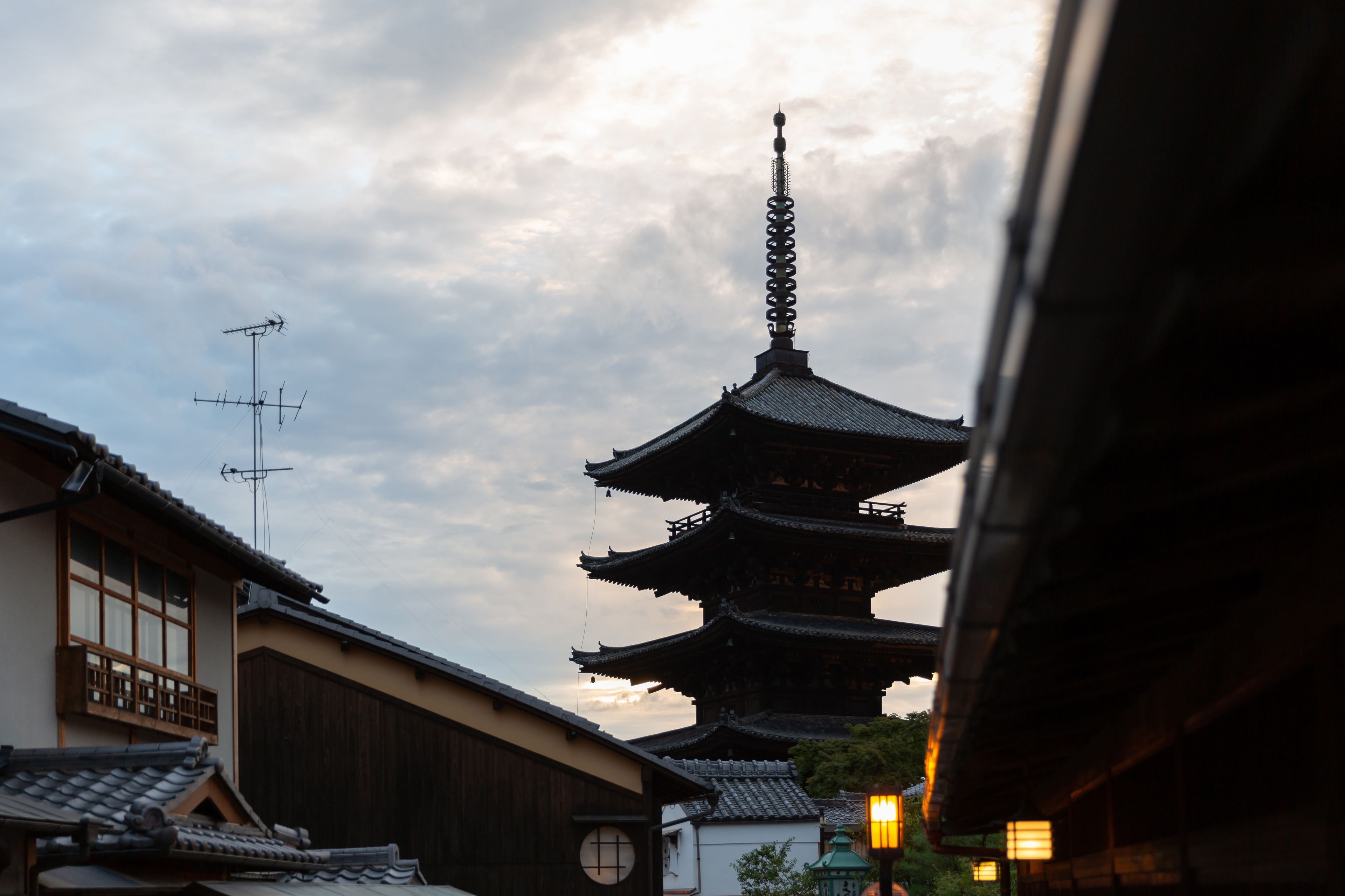 A traditional Japanese pagoda with multiple tiers, surrounded by buildings with wooden facades and tiled roofs.
