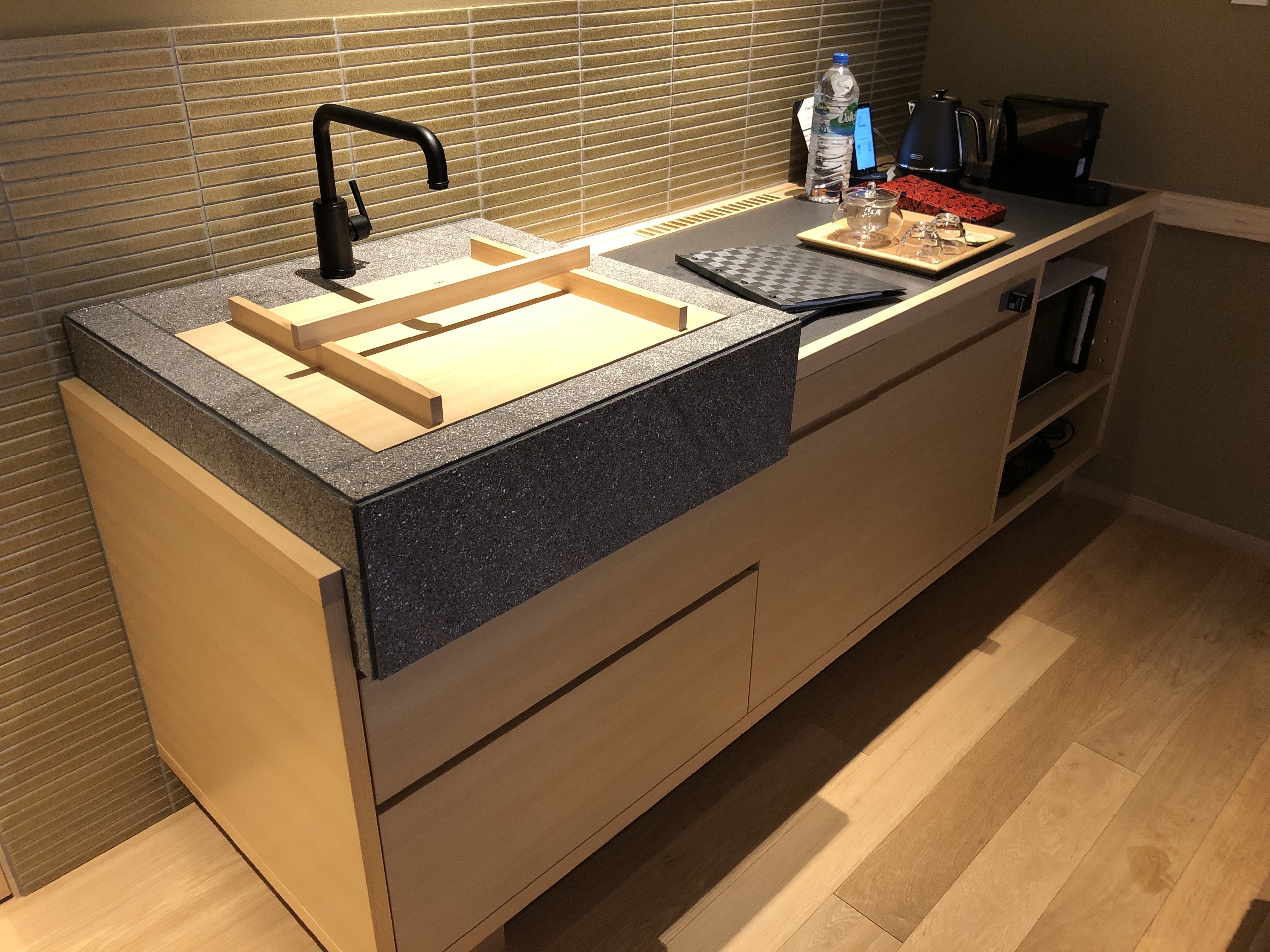 Una cocina moderna con pileta integrada, encimera de madera y cafetera.