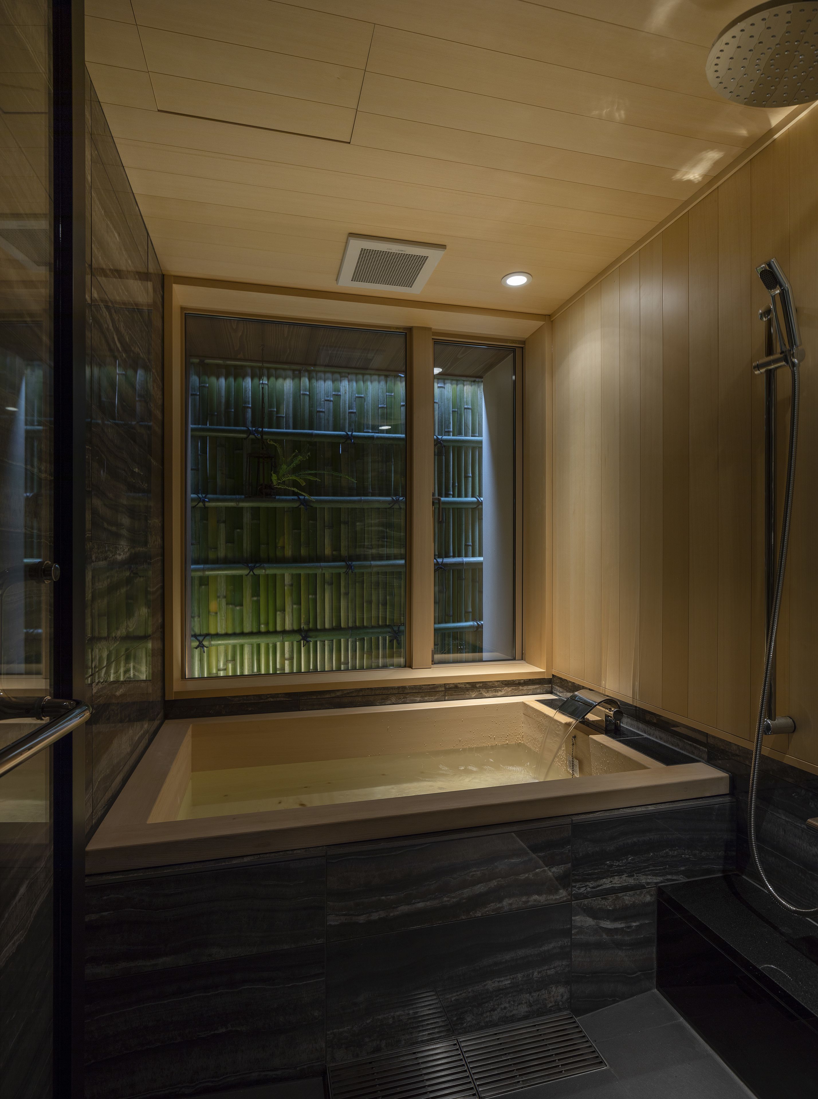 A modern bathroom with a large bathtub, a glass enclosure, and a shower area.