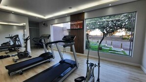 Een moderne sportschool met loopbanden, elliptische trainers en een roeimachine.