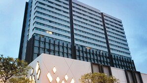 A high-rise hotel with a modern design, featuring a prominent logo at the top. - Grand Fortune Hotel Nakhon Si Thammarat (Nakhon Si Thammarat)