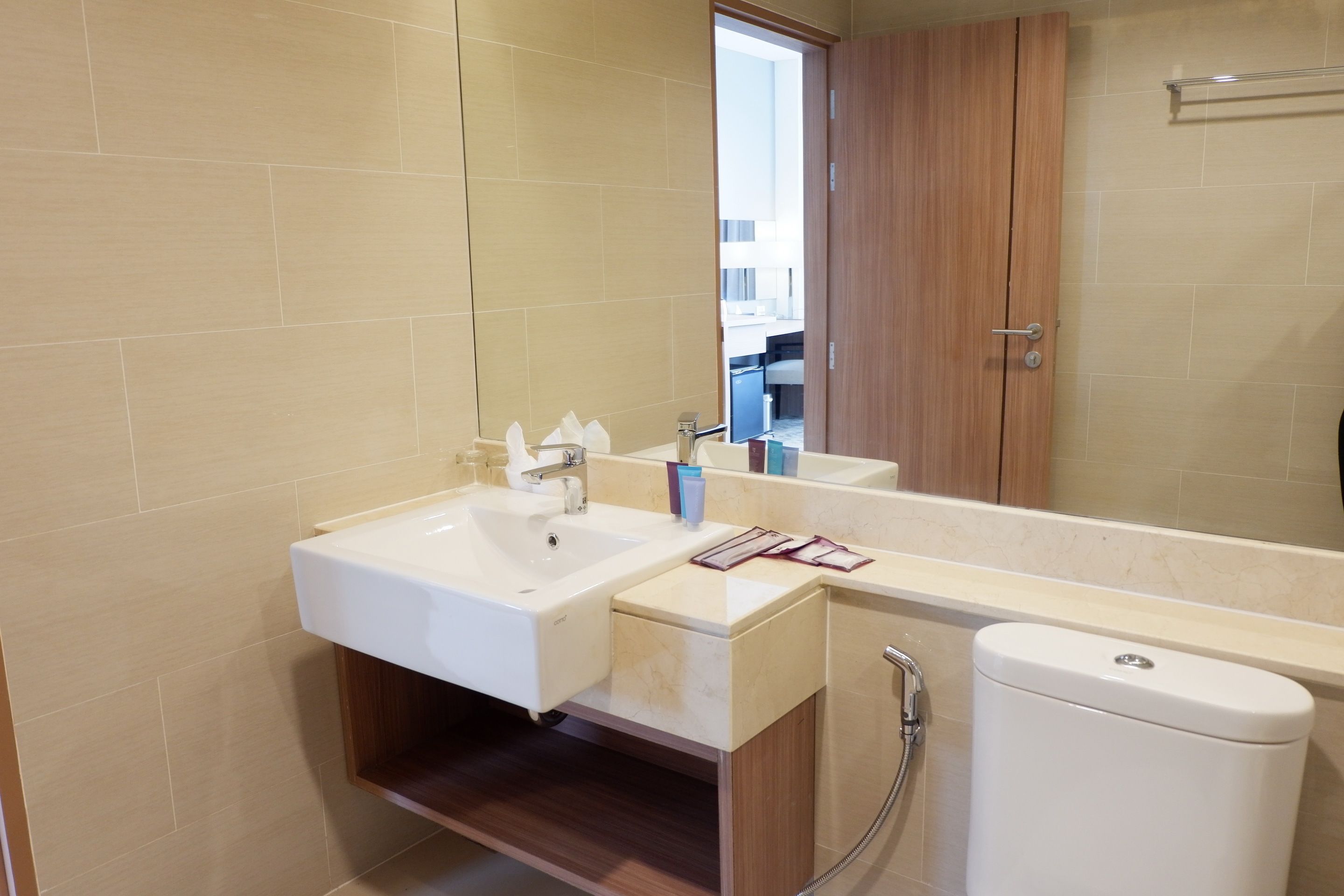A modern bathroom with a sink, mirror, and toilet.
