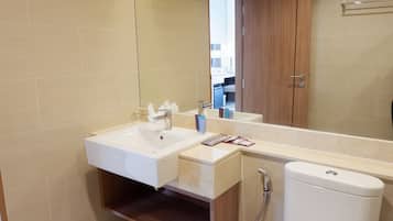 A modern bathroom with a sink, mirror, and toilet.