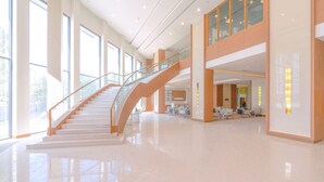 A spacious lobby with a central staircase, large windows, and a clean, modern design. - Grand Fortune Hotel Nakhon Si Thammarat (Nakhon Si Thammarat)
