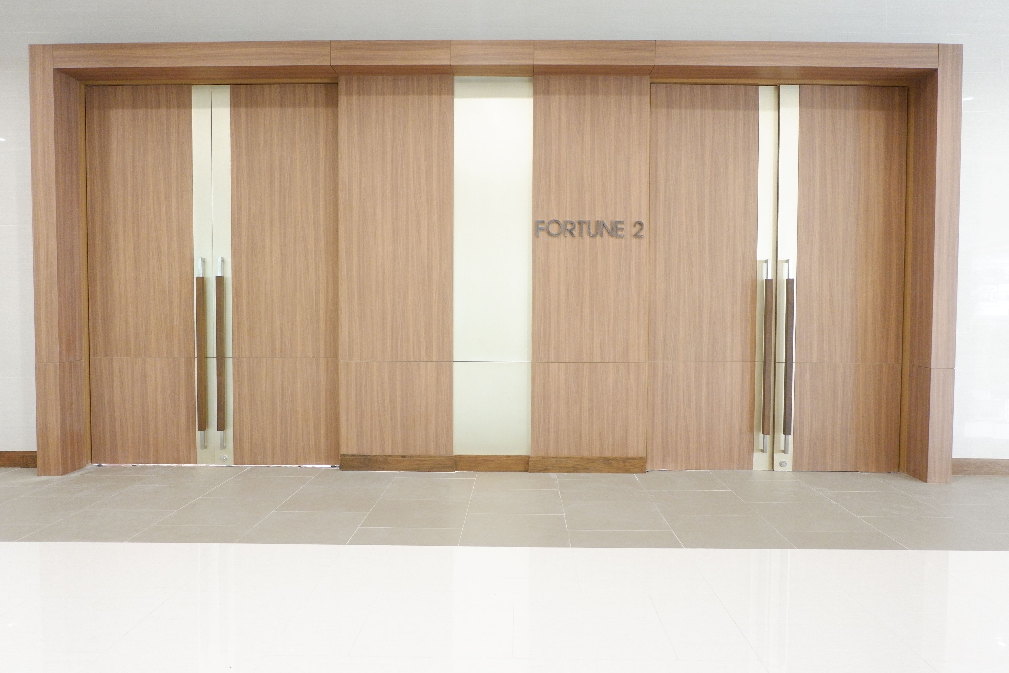 Een grote houten garderobe met het label 'FORTUNE 2' in een moderne interieurinrichting.