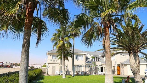 A two-story building with a sign reading "B&B" and a contact number. - Stay at Swakop Guesthouse (Swakopmund)