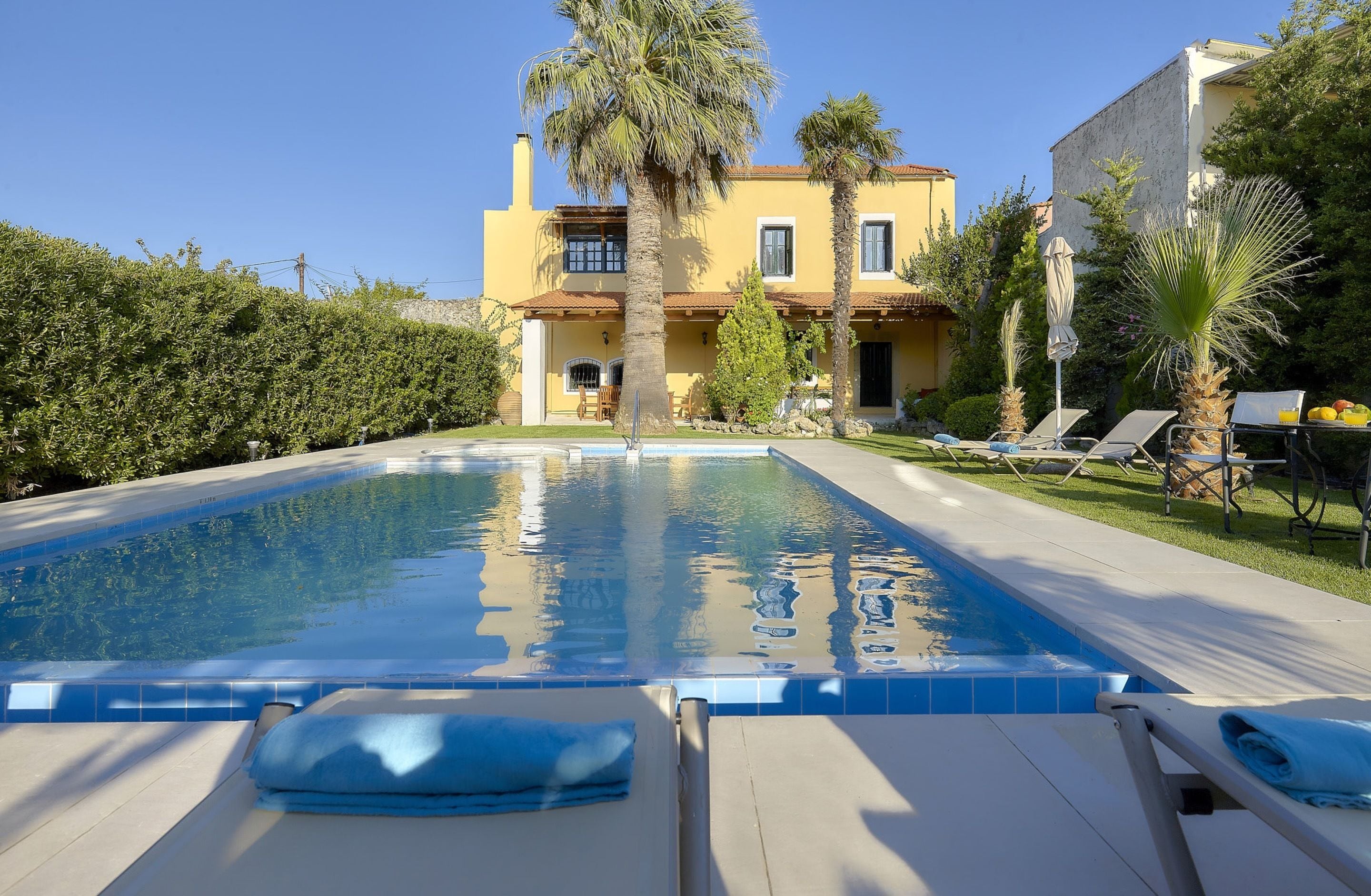 A swimming pool with lounge chairs and a building in the background.