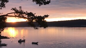 A calm lake at sunset with boats and trees. - Kodiak Awesome View Vacation Rentals: The  Captains Quarters (Kodiak)