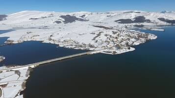 An aerial view of a snow-covered island with a bridge connecting it to the mainland.