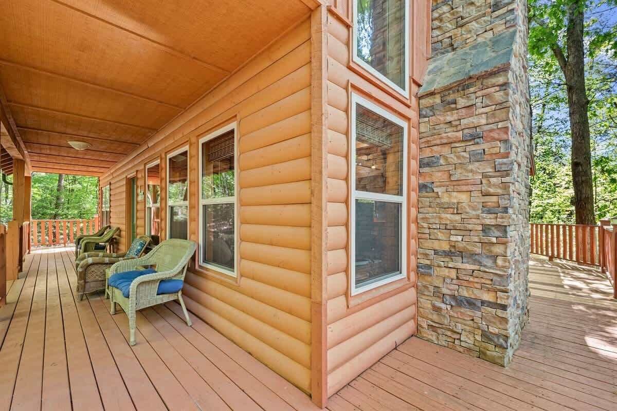 Eine Holzdiele mit Veranda, Steinmauer und Korbmöbeln.