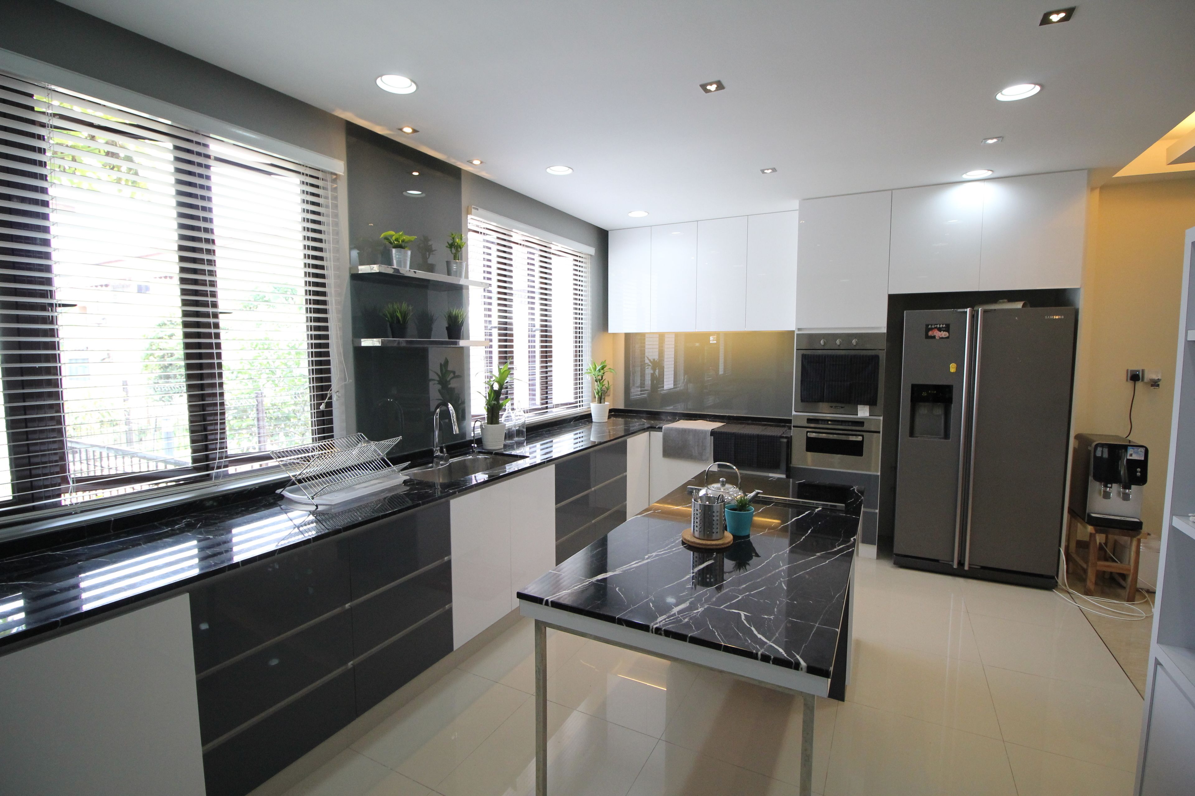 A modern kitchen with black countertops, white cabinets, and stainless steel appliances.