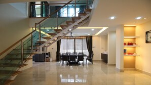 A spacious, well-lit interior with a modern staircase, a dining area, and a kitchen.