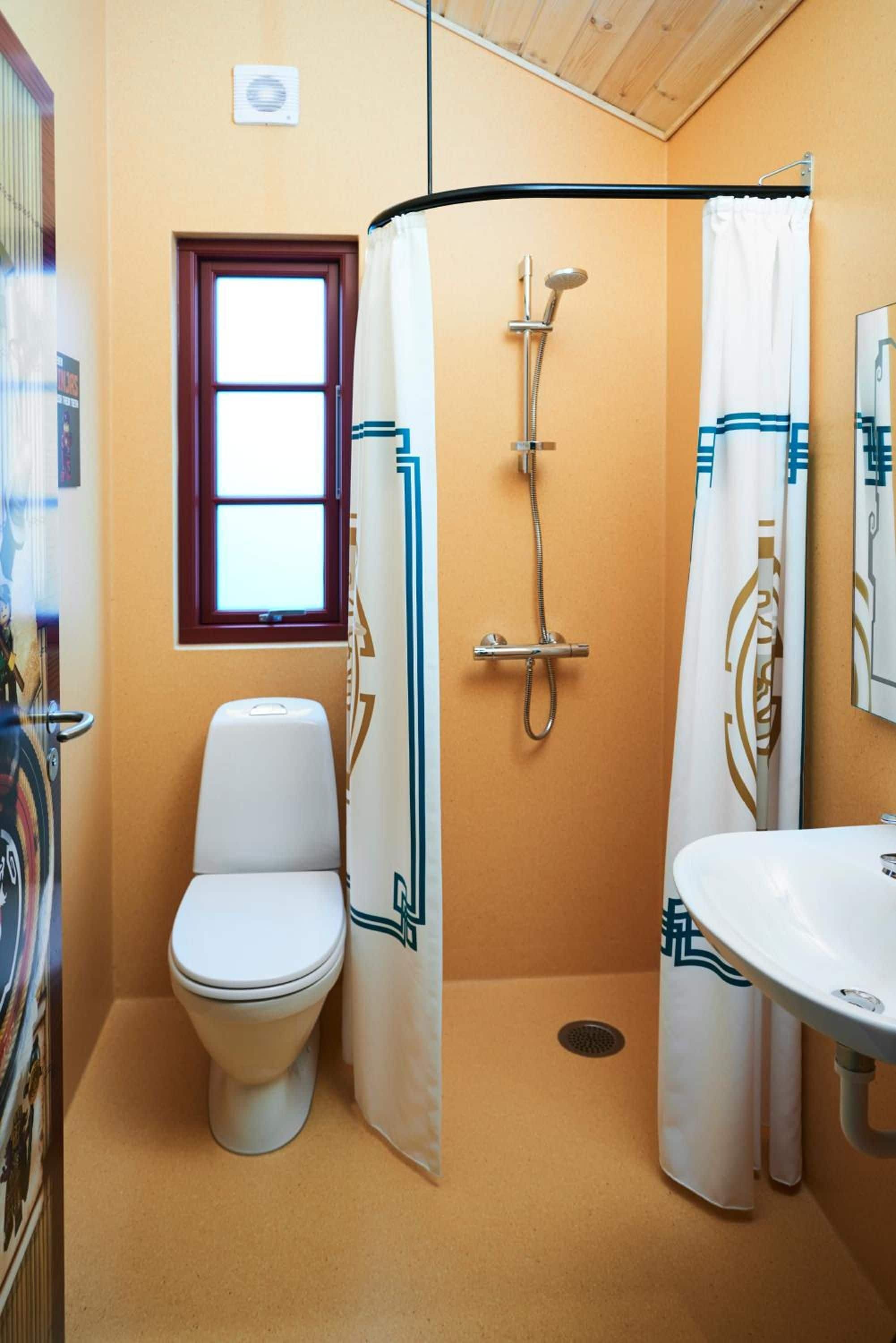 Un baño con inodoro, ducha y lavamanos.