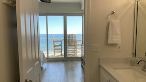 A bathroom with a large mirror, a sink, and a view of the ocean through a sliding glass door leading to a balcony with chairs. - Simply Irresistible 2 *Gulf Front View*Make A Reservation For Fun At The Beach! (Orange Beach)