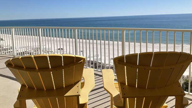 A balcony with two yellow Adirondack chairs facing a beach. - Simply Irresistible 2 *Gulf Front View*Make A Reservation For Fun At The Beach! (Orange Beach)