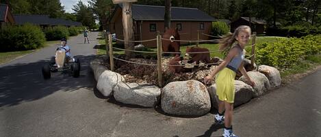 A paved road with a wooden fence and large rocks.