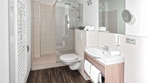 A modern bathroom with a shower, toilet, and sink. - Hotel Concordia (Euskirchen)