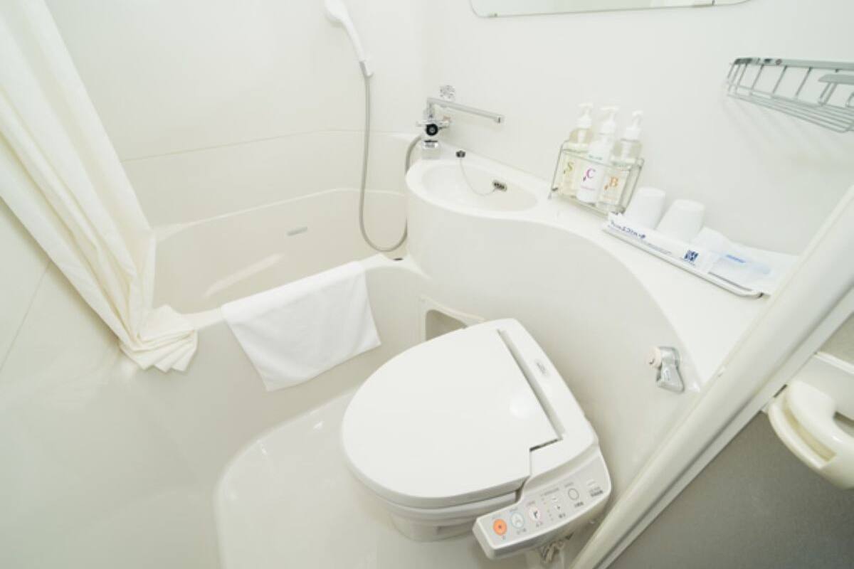 Un baño moderno con inodoro, lavabo y ducha.