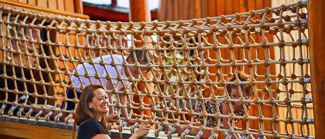 A rope bridge with wooden posts and a netted walkway.