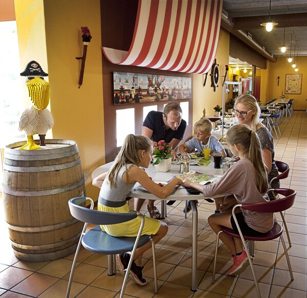 Un restaurante de temática náutica, con un barril de madera grande y un mural de un barco.