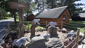 En udstilling med et tema inspireret af grævlinger, med et træskilt, et indhegnet område og en mindre bygning i baggrunden.