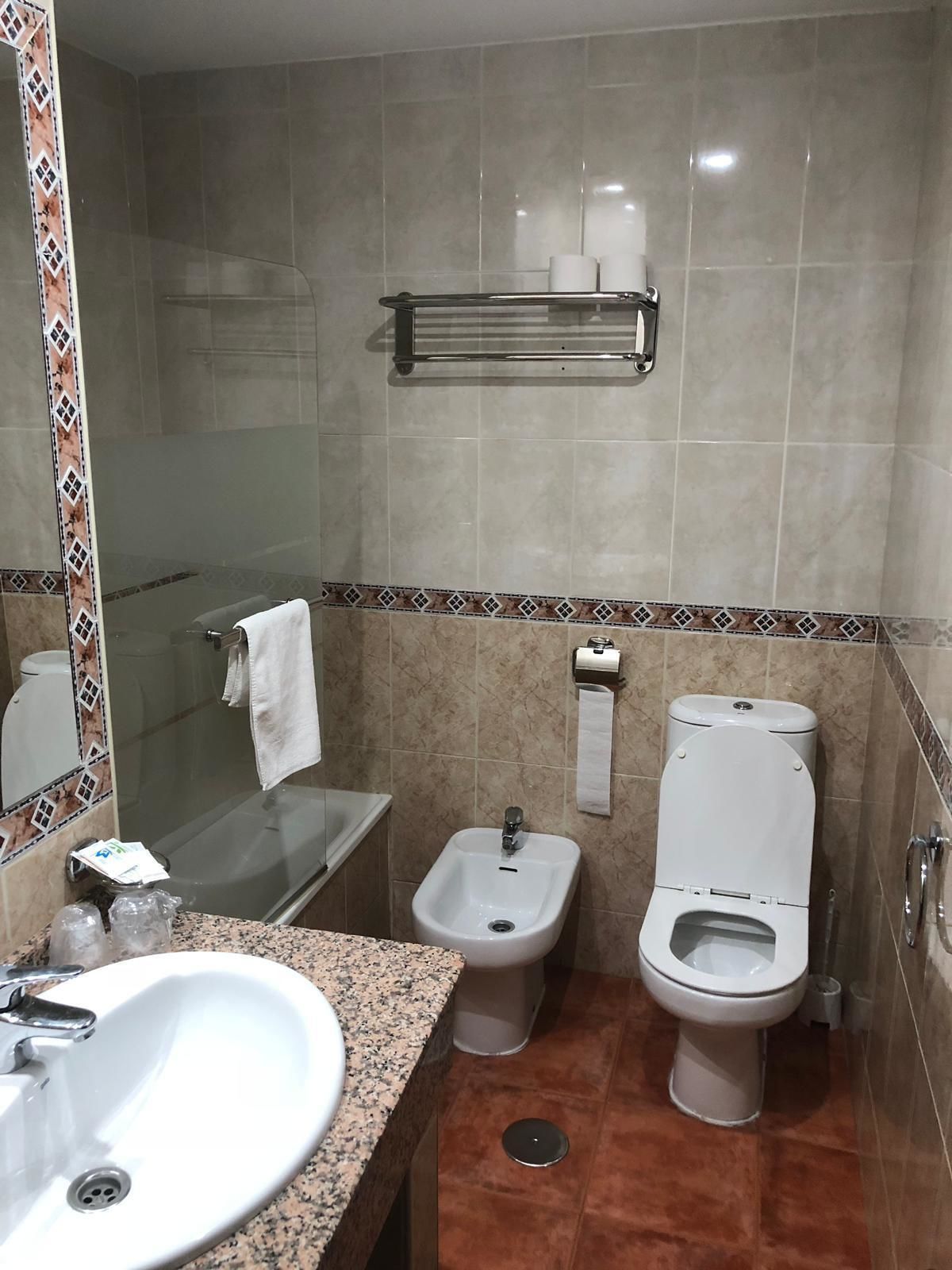 Un baño con lavamanos, bidé, inodoro y cabina de ducha de vidrio.