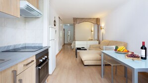 Una cocina moderna con horno empotrado y un comedor con una mesa lista para dos.