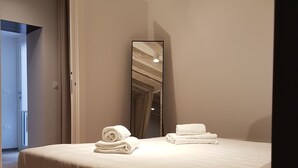 A modern hotel room with a large bed, a bedside table, and a mirror. - Corte Sconta Mini Loft (Venice)