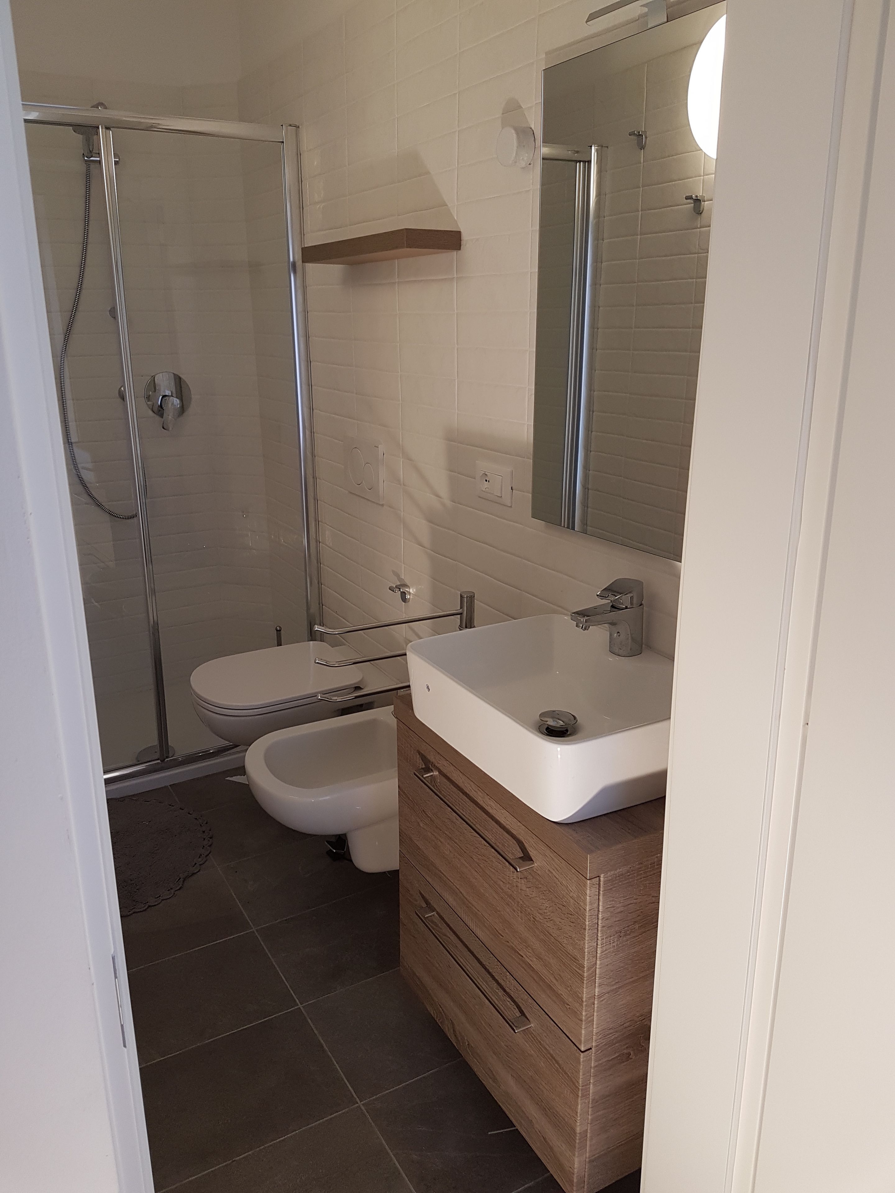 A bathroom with a shower, toilet, and sink.