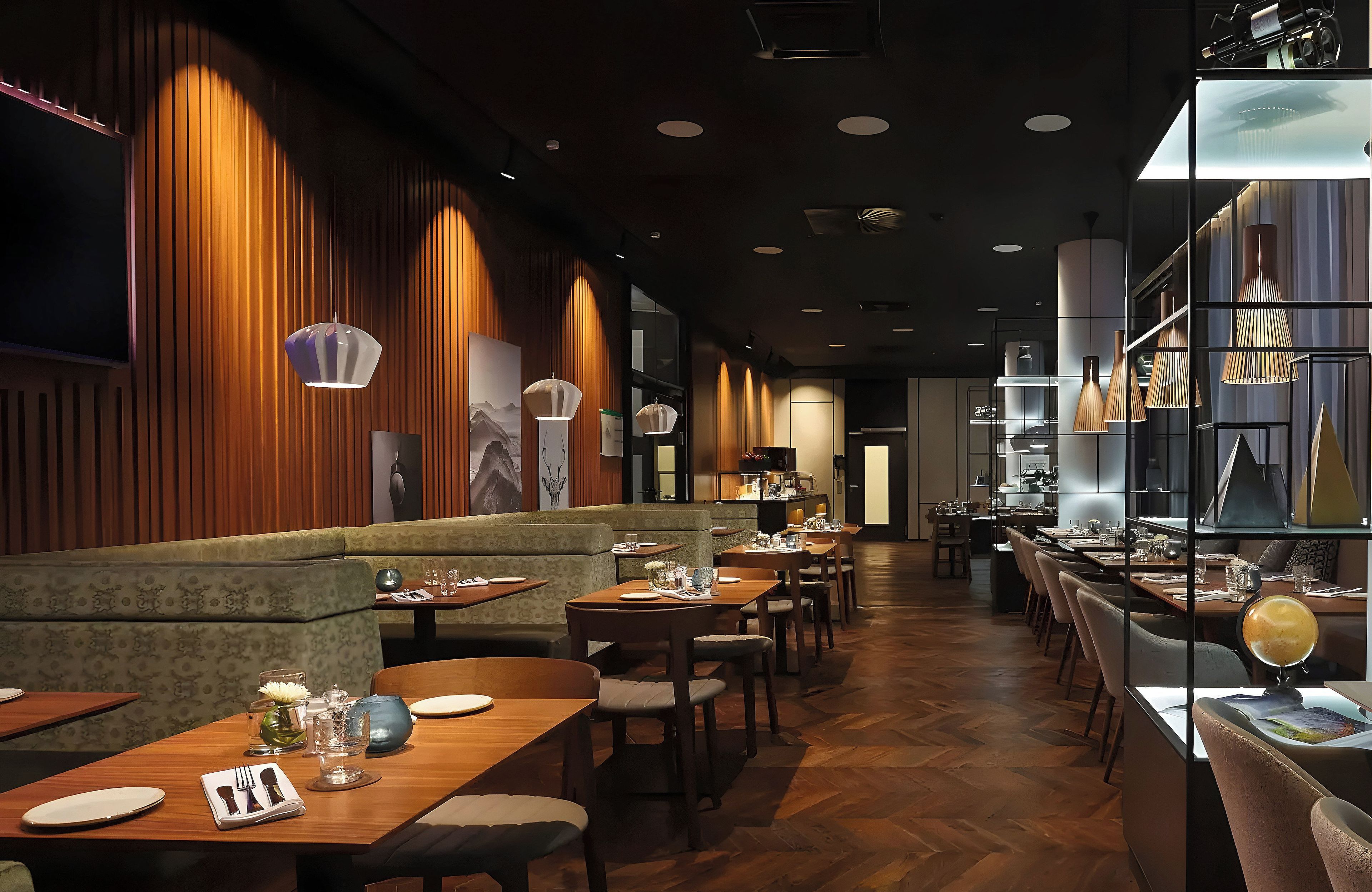 Ein Restaurantinnenraum mit Holzwandverkleidung, einer langen Theke und mehreren Tischen.