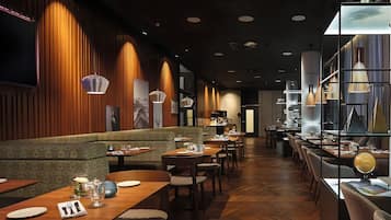 Un interior de restaurante con paneles de madera, una barra larga y varias mesas.