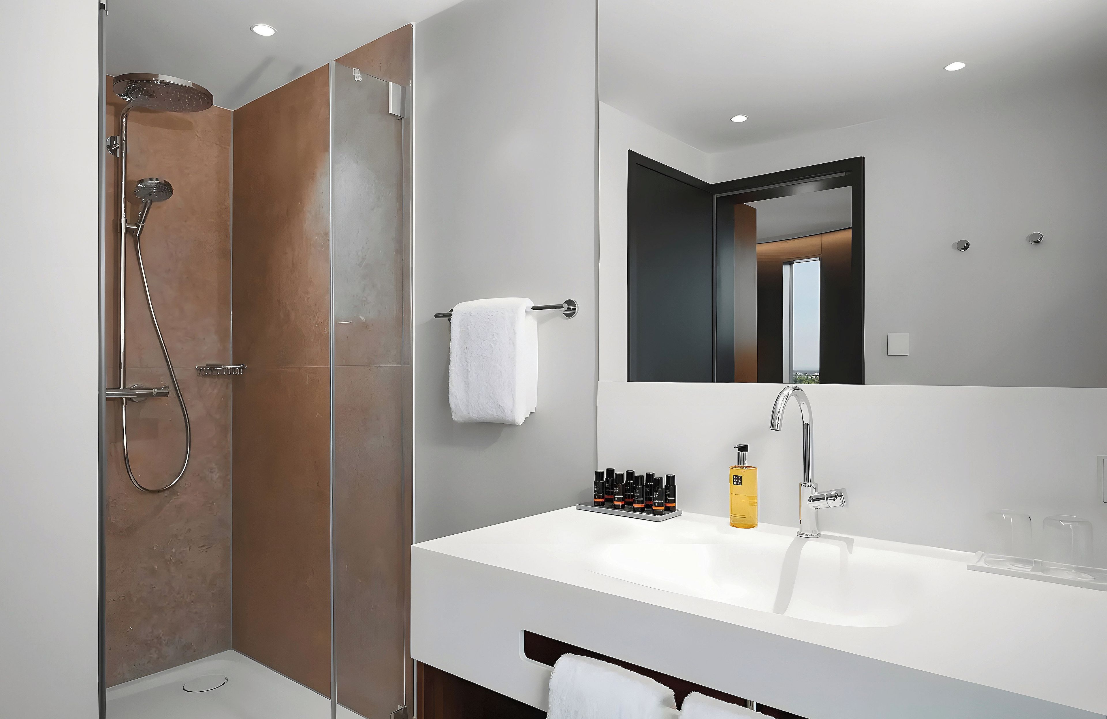 Ein modernes Badezimmer mit Dusche, Waschbecken und Spiegel.