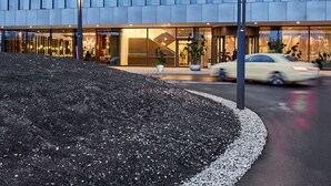 A modern building with a "Hyperion" sign, featuring a geometric facade and a well-lit entrance. - HYPERION Hotel München (Munich)