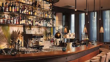 A bar area with a variety of liquor bottles, a coffee machine, and seating.