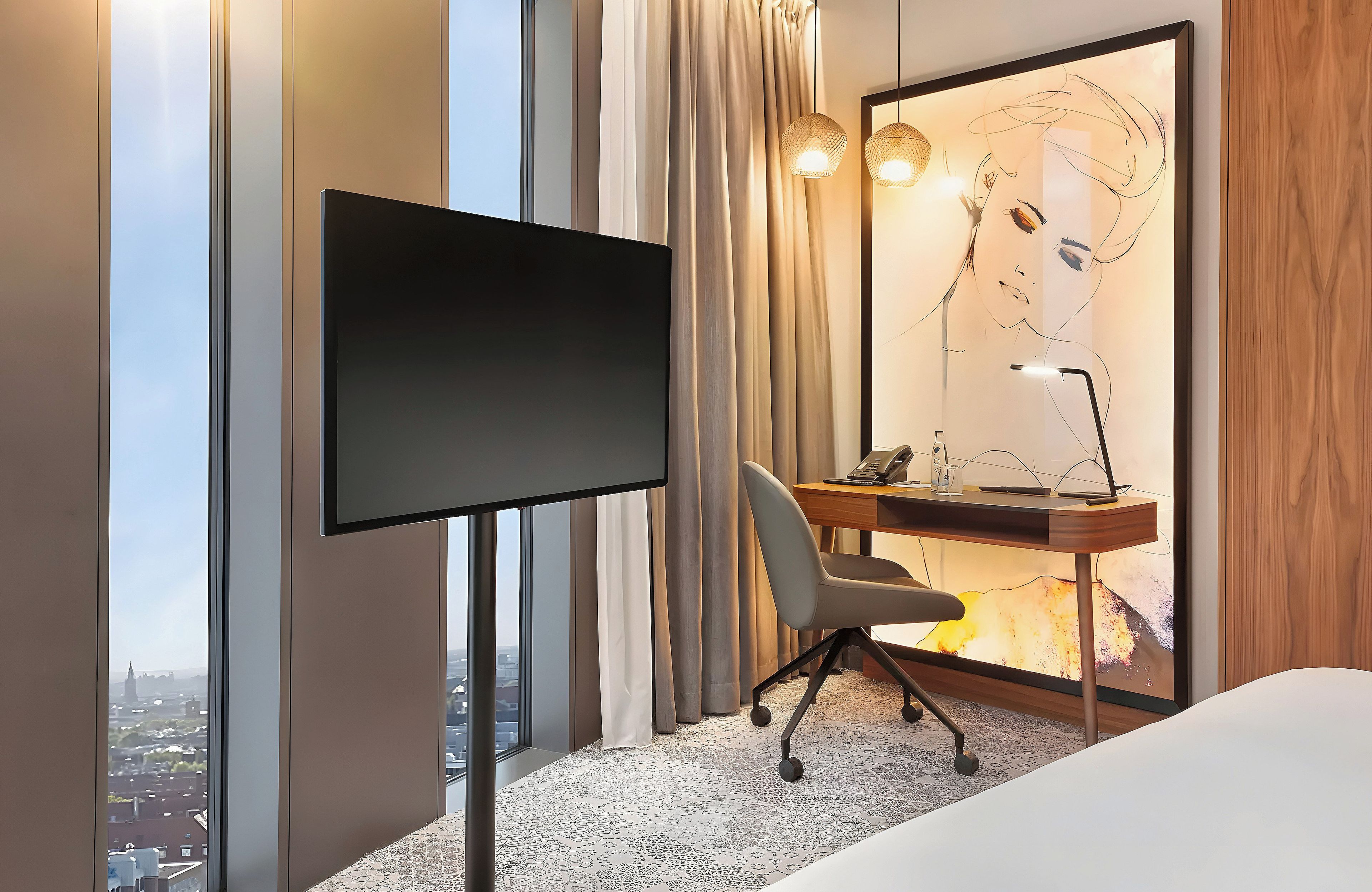 Una habitación de hotel con un ventanal grande, un escritorio con una silla, un televisor de pantalla plana y una cama.