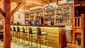 A bar area with wooden beams, a bar counter, and seating. - Wellness Hotel Ondrášův Dvůr (Bílá)