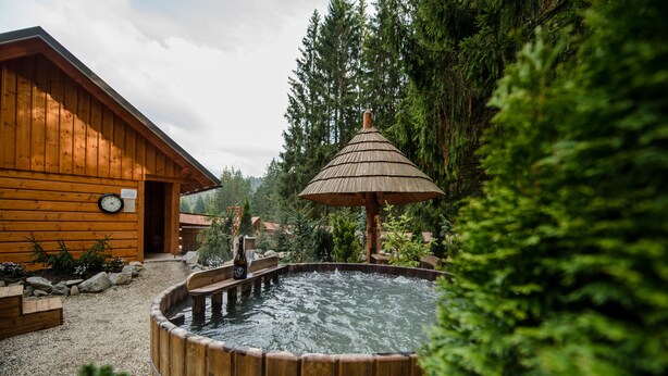 A wooden cabin with a hot tub and a wooden deck. - Wellness Hotel Ondrášův Dvůr (Bílá)