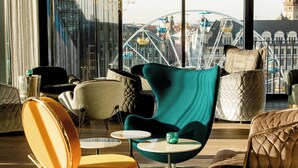 Un espace de détente moderne, doté de sièges confortables et offrant une vue sur une grande roue.