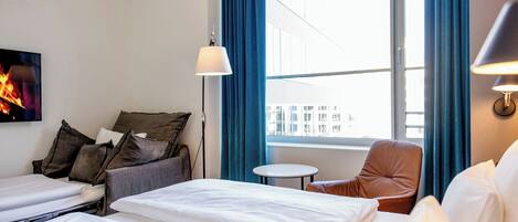 Una habitación de hotel con una cama, una silla, una mesita y un televisor.