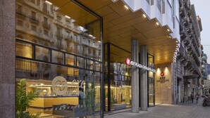 Exterior del hotel Excelsa Catalunya, con amplias ventanas de vidrio, una zona de recepción y un diseño arquitectónico moderno.
