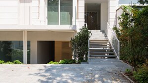 A modern two-story house with a front entrance, a staircase, and a small garden area. - Home at Hotel Boccherini luxury studio (Milan)