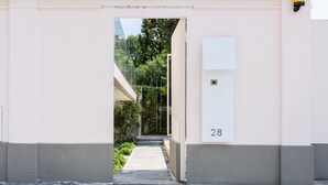 A narrow pathway leading to a building entrance with a number '28' sign. - Home at Hotel Boccherini luxury studio (Milan)