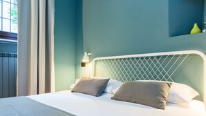 A neatly made bed with two pillows, a white headboard, and a bedside lamp. - Home at Hotel Naviglio - Sambuco Apt (Milan)