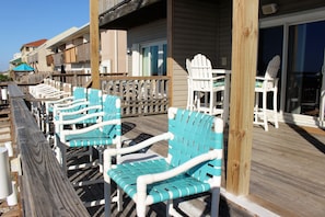 A wooden deck with rows of white and turquoise Adirondack chairs. - Dolphin Watch 3 Bedroom Townhouse by RedAwning (Navarre)