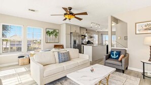 A spacious living area with a sofa, coffee table, and a ceiling fan. - Pelican Roost 2 Bedroom Townhouse by RedAwning (Navarre)